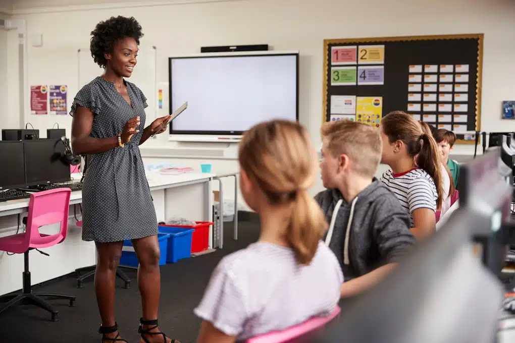 Teacher using digital screen signage to teach students at school.