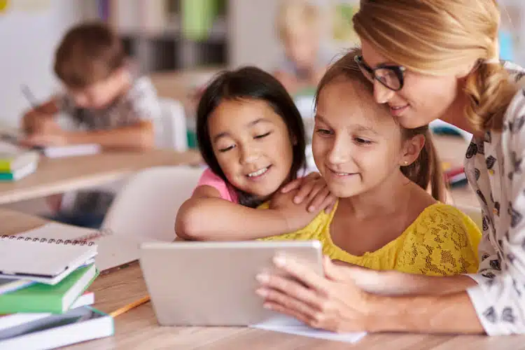 teacher teaching kids in the classroom using ipad